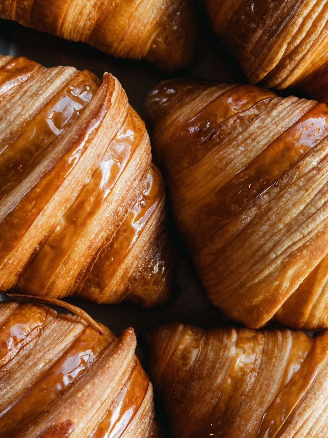 A pile of golden SANI Bakehouse croissants fresh from the oven